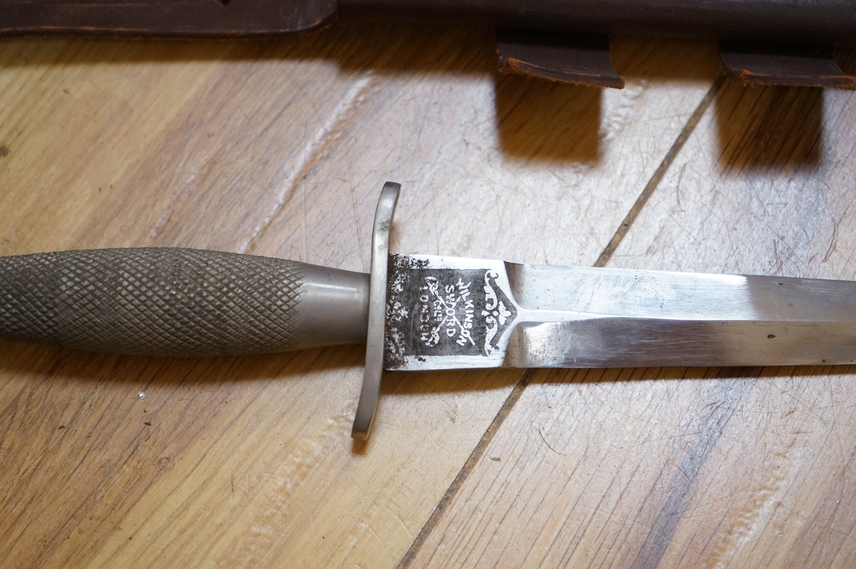 A Sykes-Fairburn Fighting Knife by Wilkinson sword in its leather scabbard, together with a 1942 Mk.III military compass by T.G.Co.Ltd. in a webbing pouch dated 1940, together with another compass, a telescope in a leath